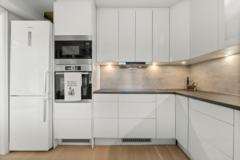 MöbelTech - Nowoczesne meble na wymiar Sleek modern kitchen featuring white cabinetry, built-in appliances, and minimalist design.